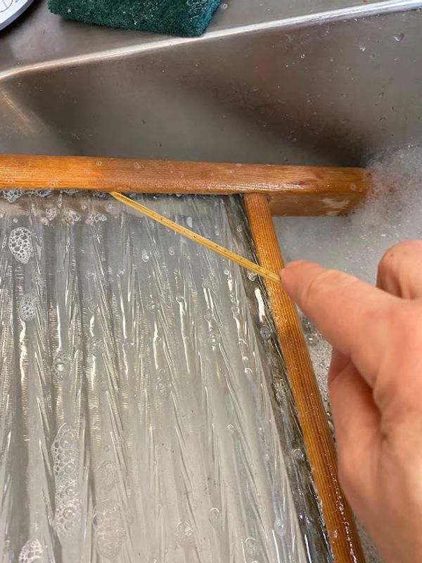 Thrifted Washboard Farmhouse Makeover Photo of a vintage washboard being cleaned in the kitchen sink.