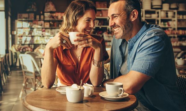 A happy couple laughing over coffee