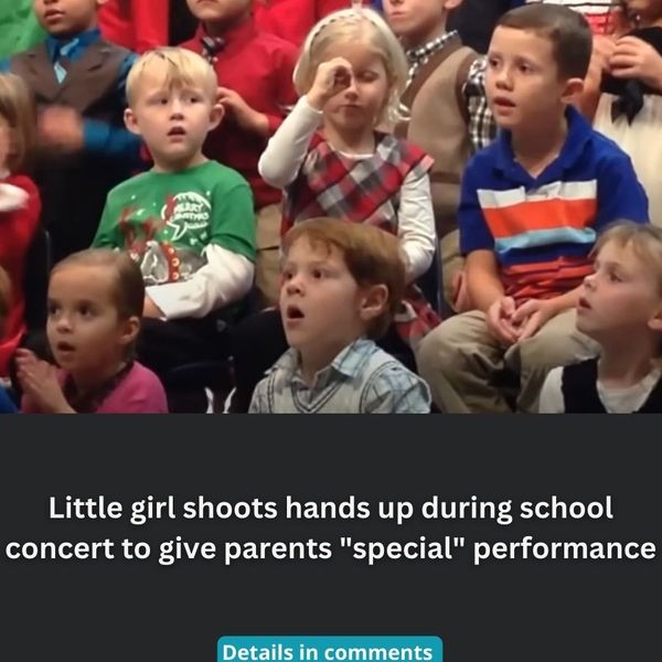 Little girl shoots hands up during school concert to give parents “special” performance