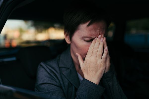 Anxious woman sitting in the back of a car