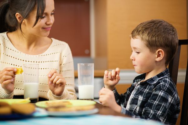 A young mother and her little son eating breakfast | Source: Shutterstock