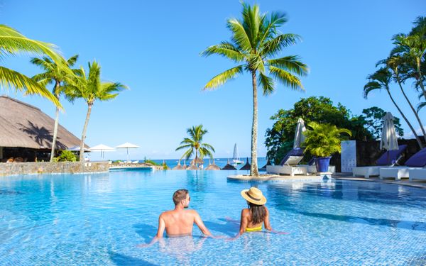 A couple relaxing in a swimming pool on a vacation | Source: Shutterstock